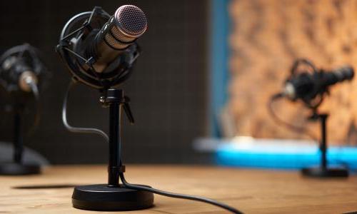 A podcasting setup with microphones on short desk stands.